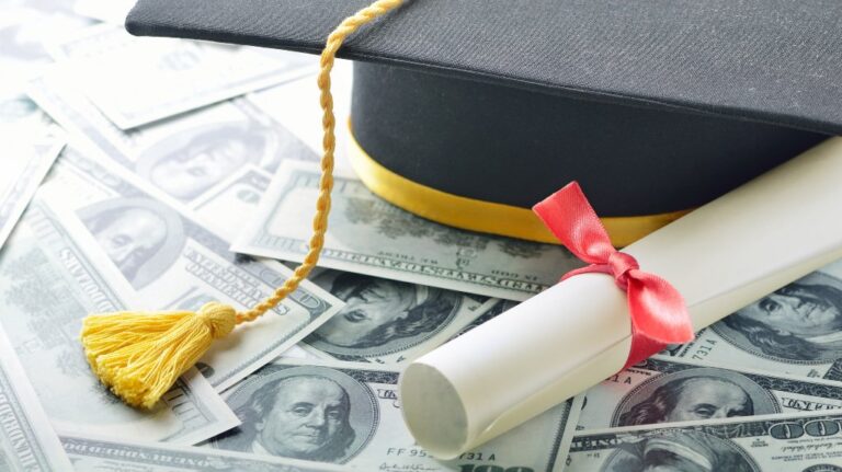 Graduation cap and diploma sitting on money