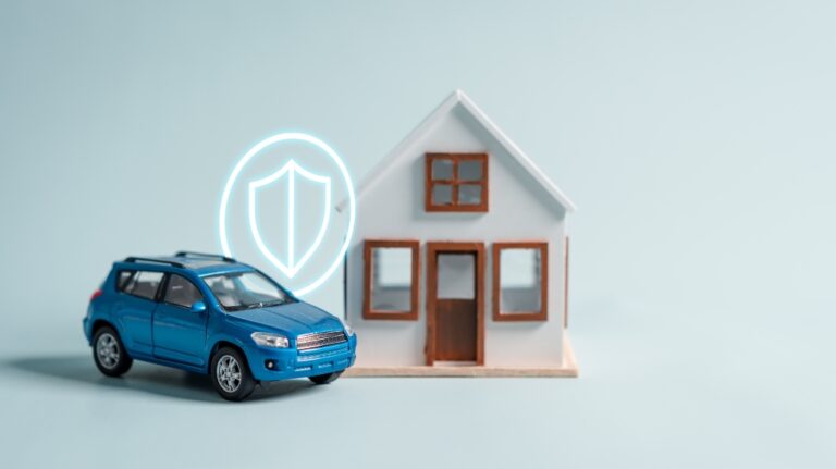 A blue toy car is parked in front of wooden house model with a shield