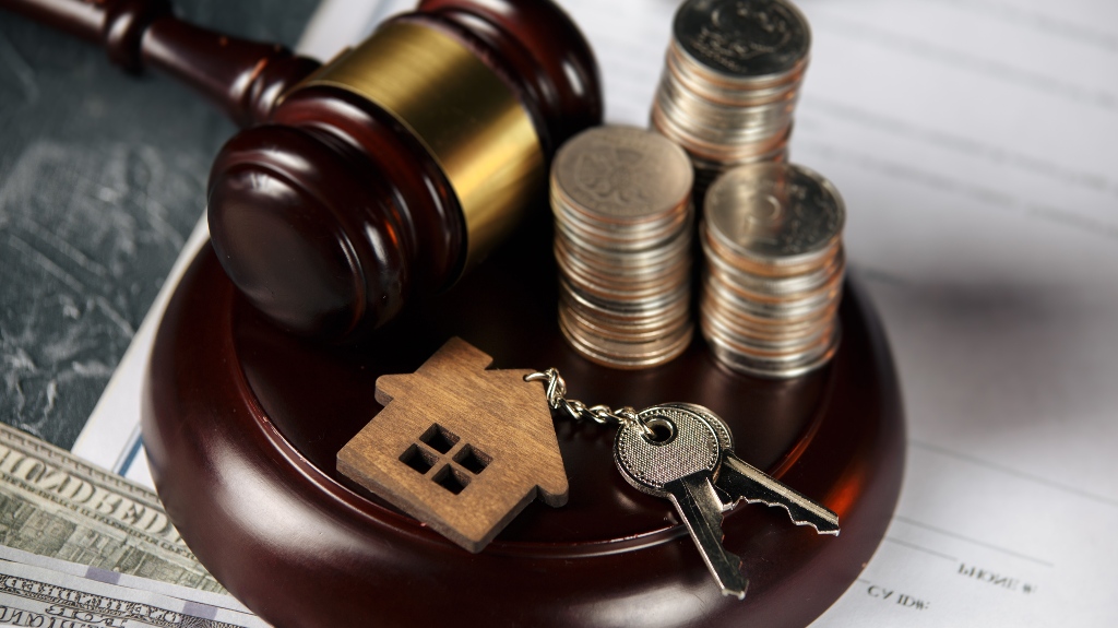 Judge gavel, coins and wooden model of house