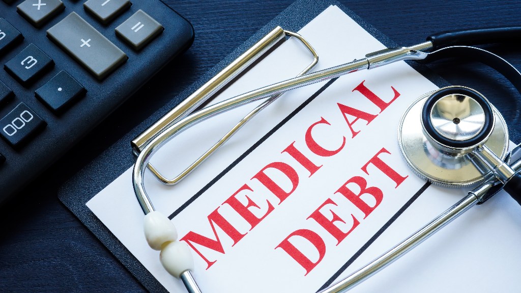 Medical debt bill in the clipboard and stethoscope