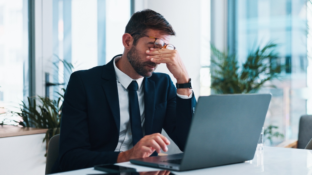 Frustrated, businessman with laptop on the table
